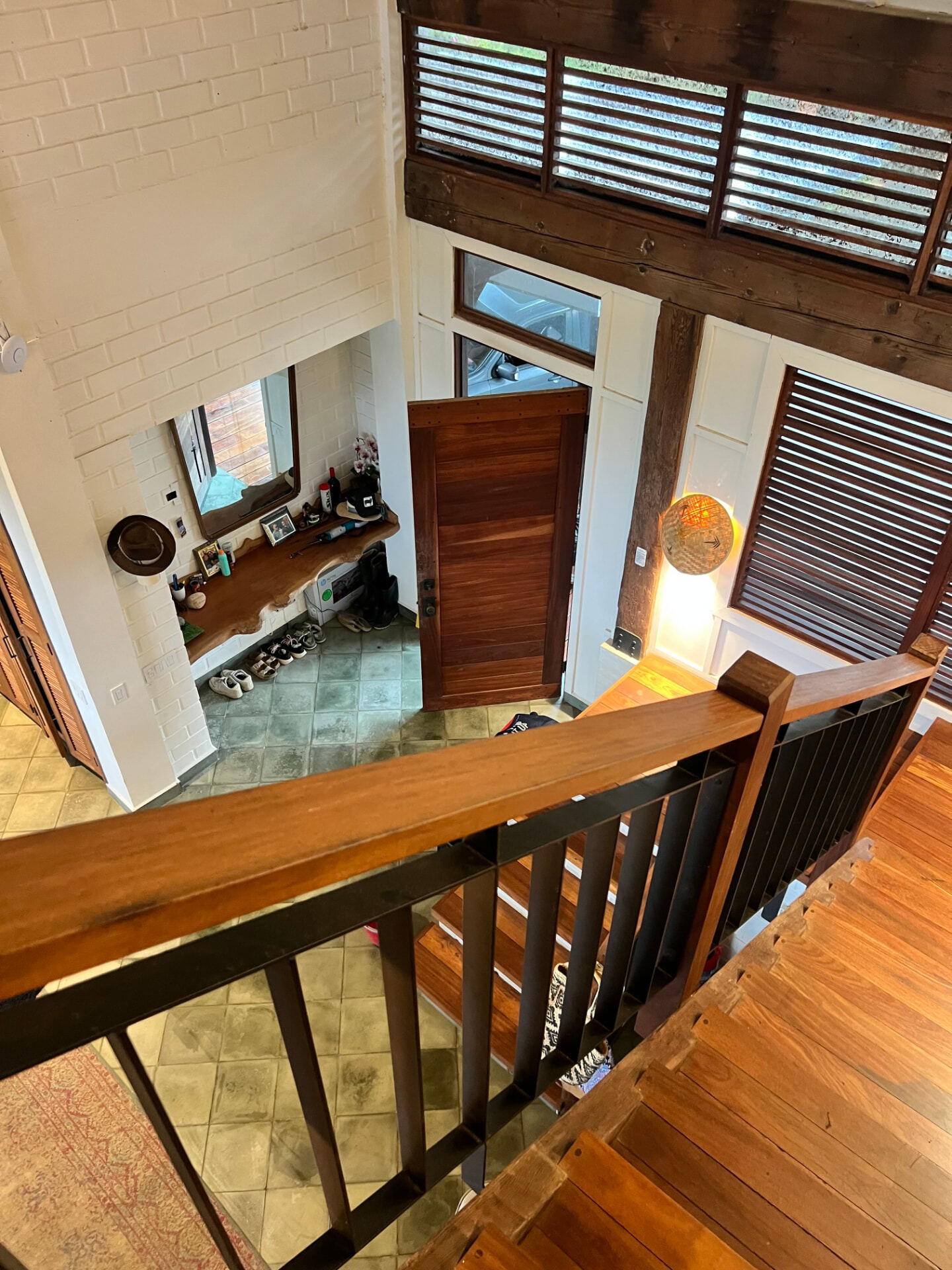 Hardwood stair and rail looking down to the tiled entrance hall of the main villa