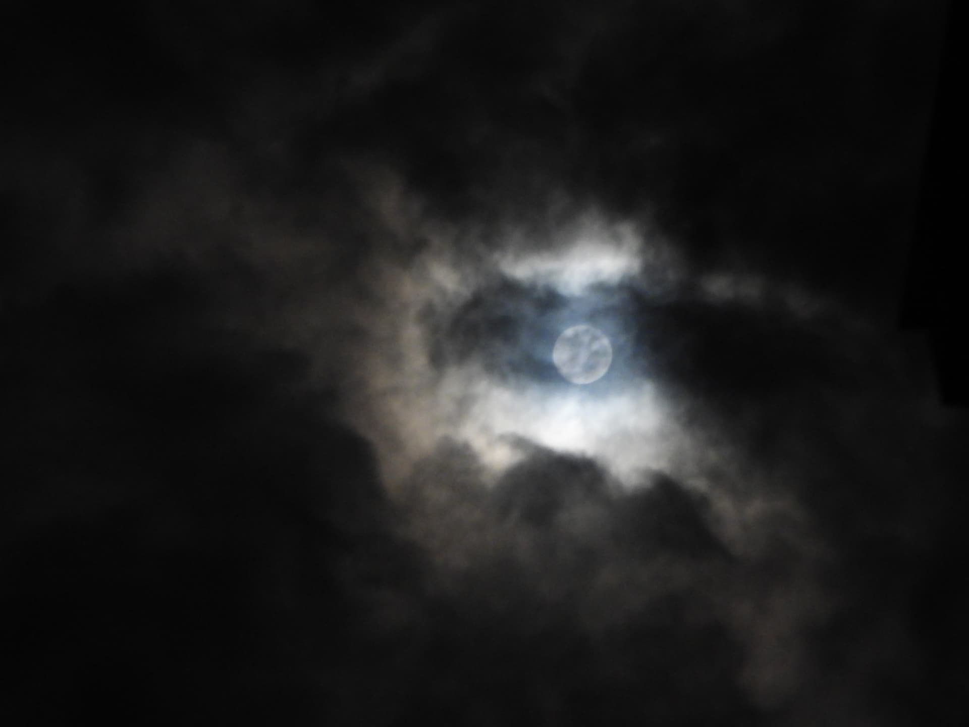 Moon shining through night clouds above the estate