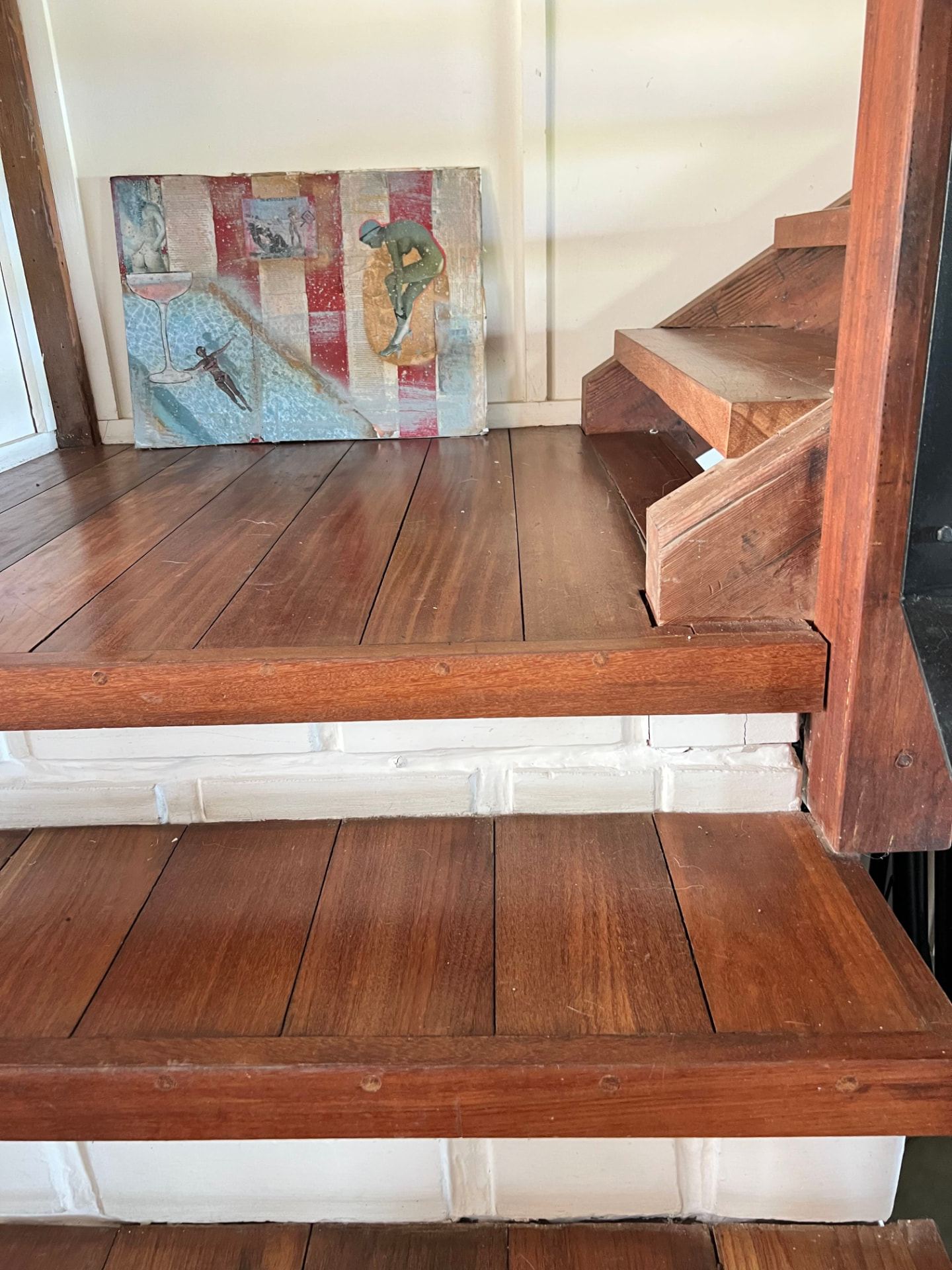 Solid tropical hardwood stairs and floorboards meeting a lime-washed brick base in the main house