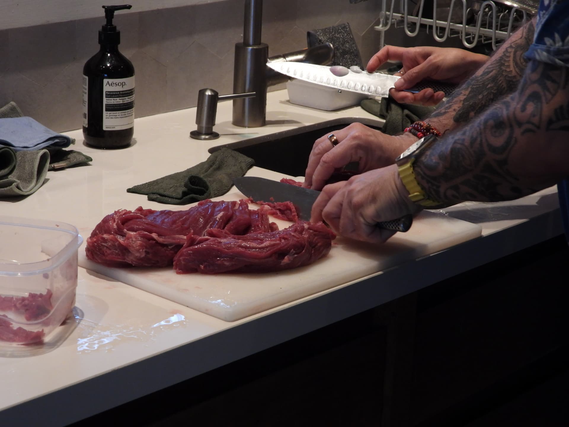 Hands preparing fresh meat on the kitchen counter at Denter Tumas