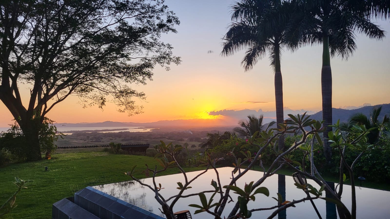 Sunset over the hills and ocean from the pool at Denter Tumas