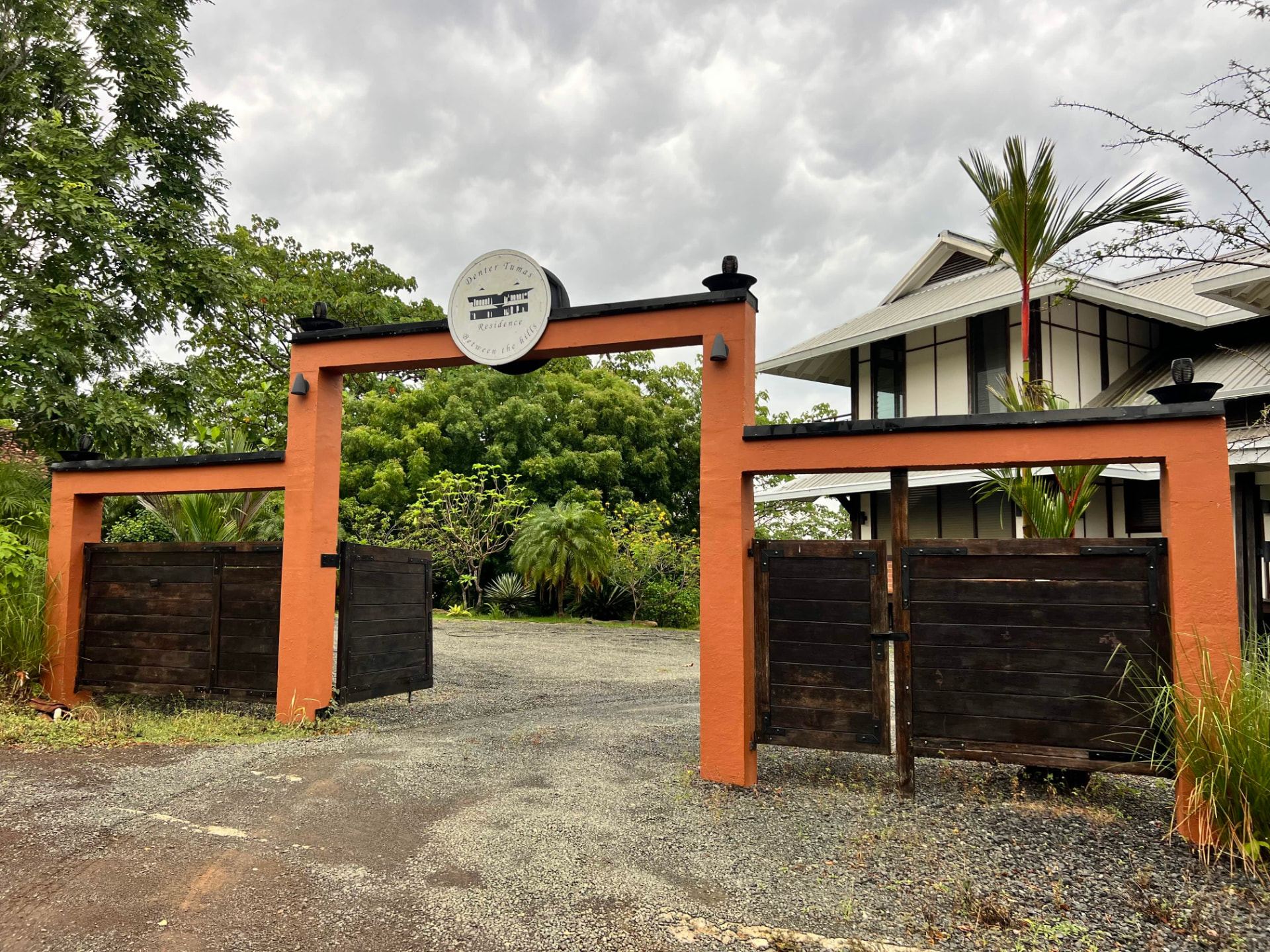 The entrance gate of Denter Tumas opening onto the gravel driveway
