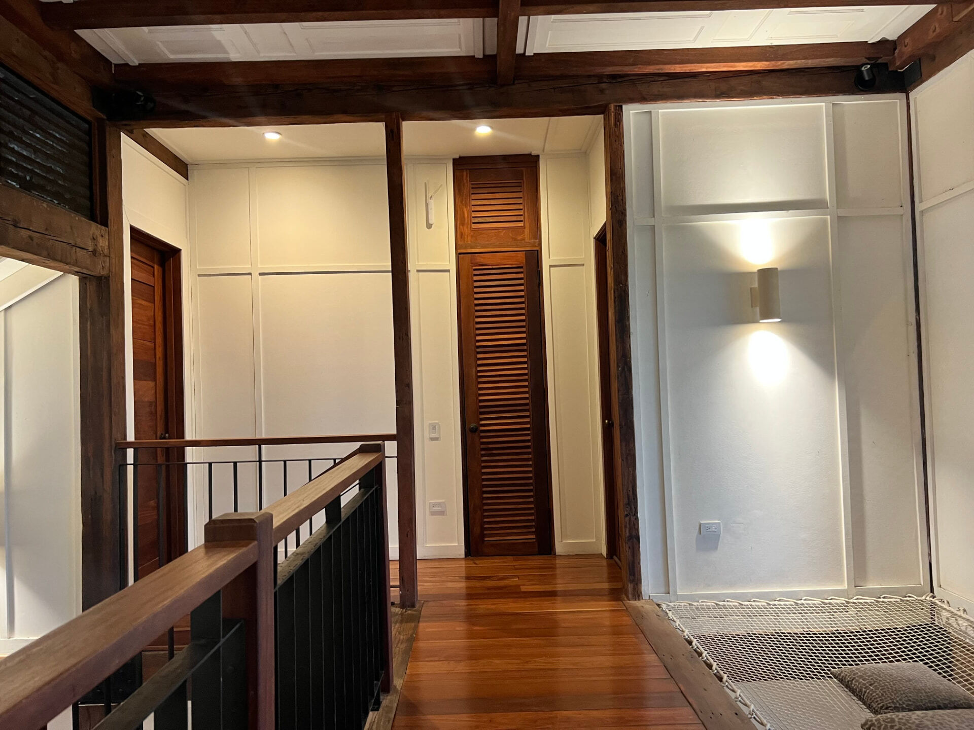 Upstairs hallway with timber floors, panelled walls and a suspended rope net